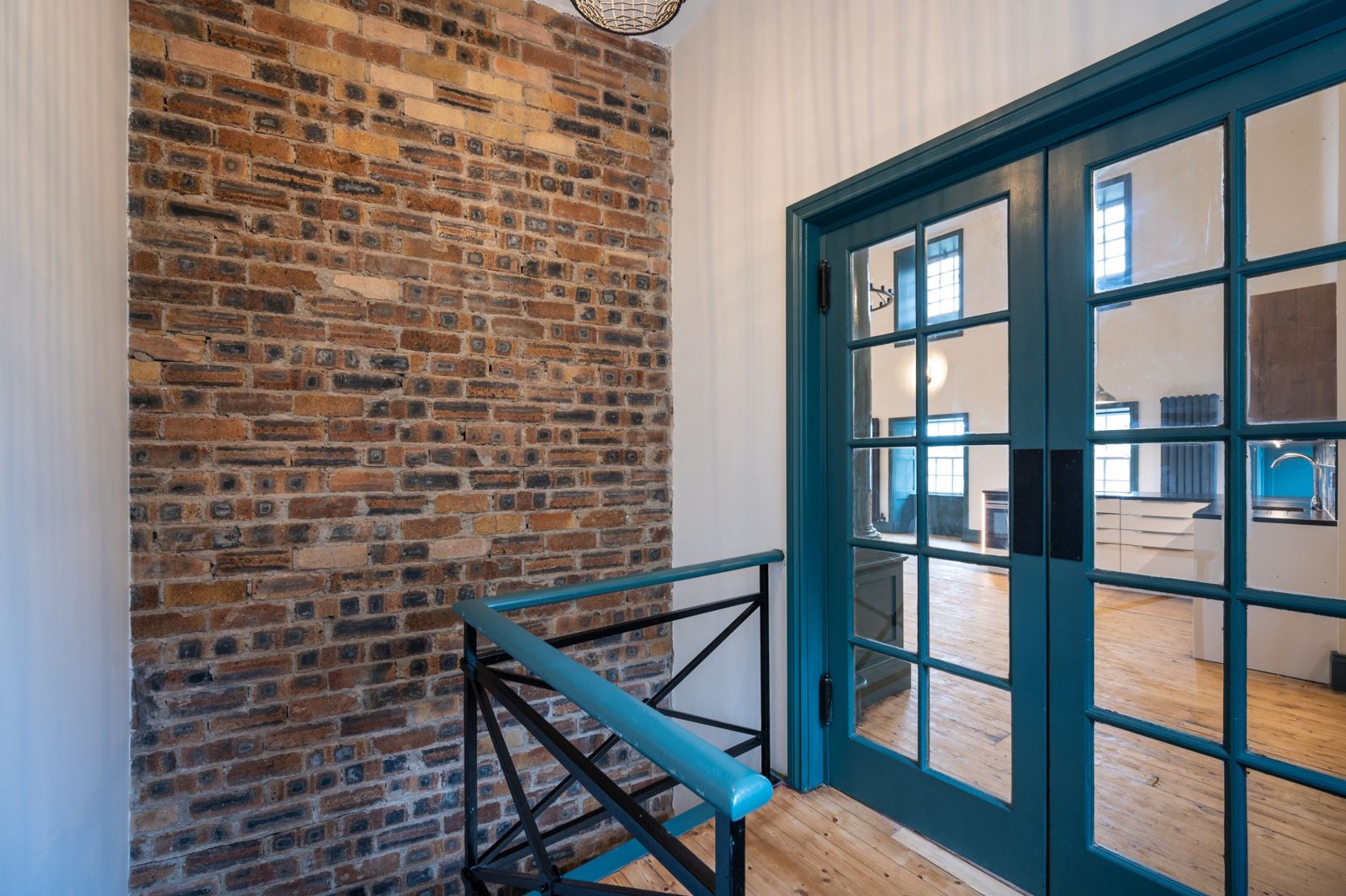 Landing with exposed brick and glazed doors