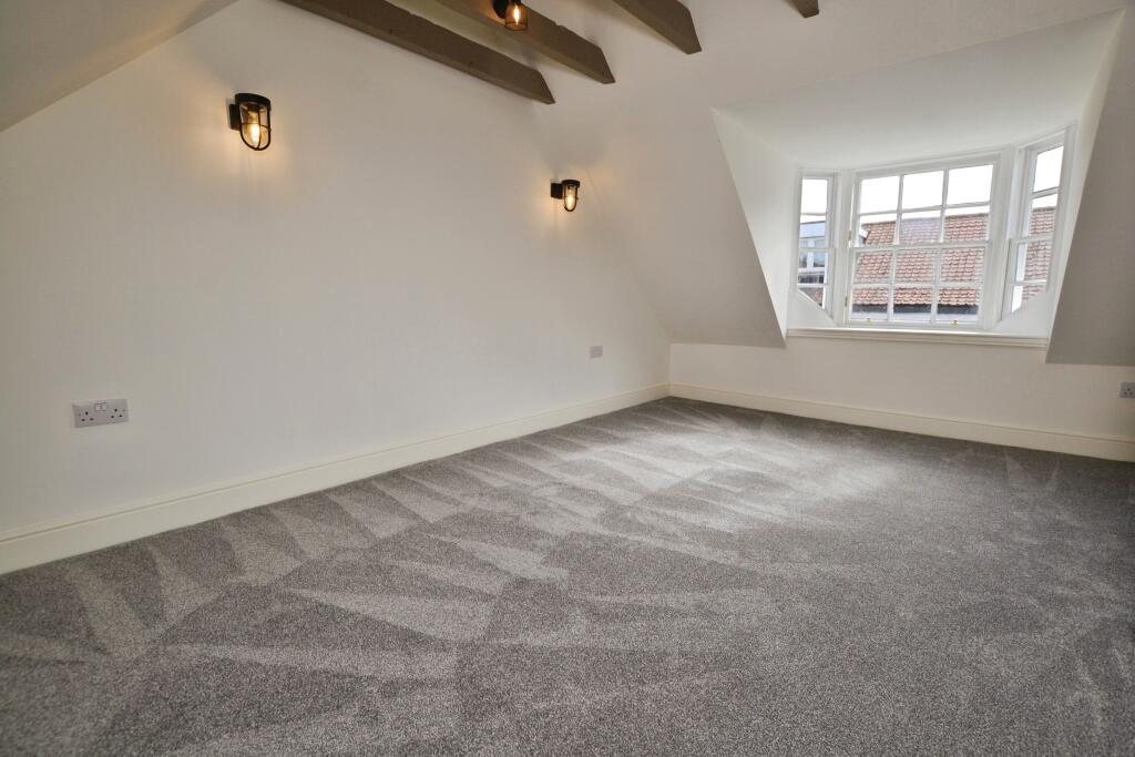 Top floor bedroom with dormer window and exposed beams